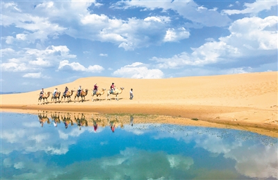 游客在烏海湖旅游區(qū)享受沙漠風(fēng)光。烏海湖東臨烏海市濱河景觀帶，西接烏蘭布和沙漠，南接黃河烏海段上段河道，北接水利樞紐大壩，豐富的景觀與平靜如鏡的湖水融為一體，讓人流連忘返。本報(bào)記者 懷特烏勒斯 攝