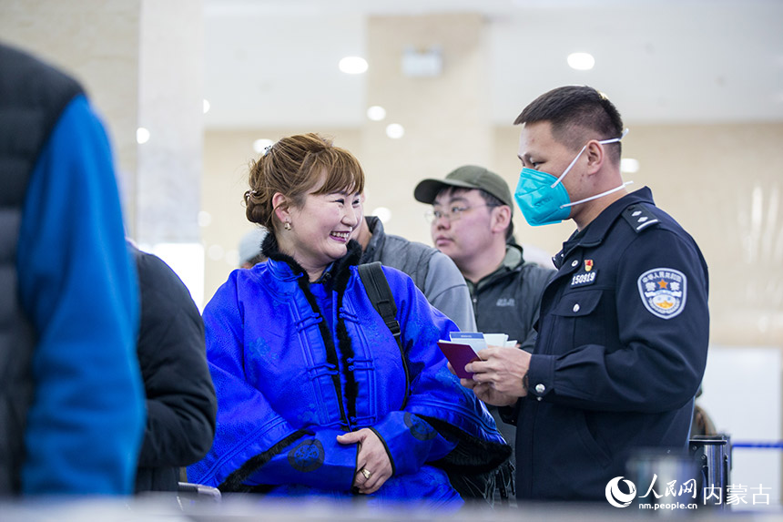 二連出入境邊防檢查站執(zhí)勤民警為旅客提供通關咨詢。郭鵬杰攝