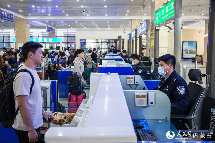 二連出入境邊防檢查站執(zhí)勤民警為旅客辦理通關(guān)手續(xù)。胡富國攝