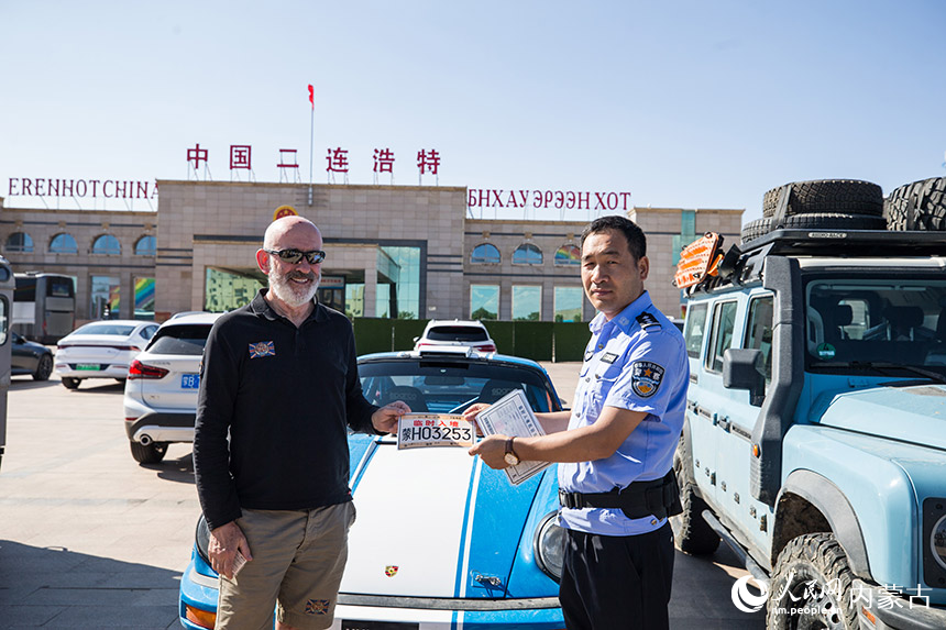 為自駕旅游團(tuán)成員發(fā)放臨時(shí)入境號(hào)牌。郭鵬杰攝