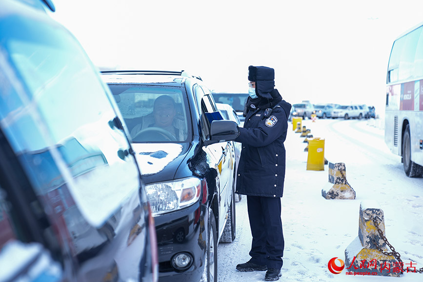 11月28日，二連出入境邊防檢查站執(zhí)勤民警頂風(fēng)冒雪快速驗(yàn)放通關(guān)車輛。楊金燁攝
