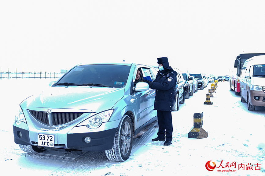 11月28日，二連出入境邊防檢查站執(zhí)勤民警頂風(fēng)冒雪快速驗(yàn)放通關(guān)車輛。楊金燁攝