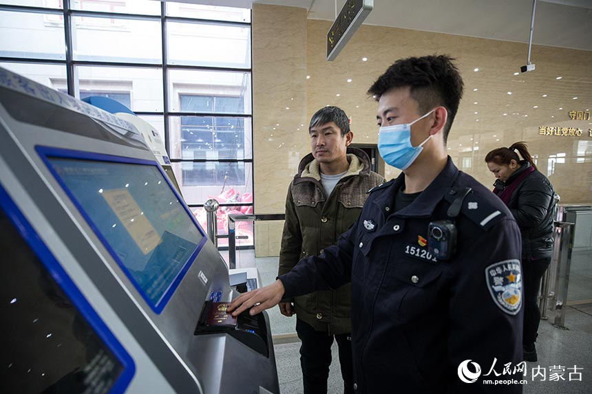 二連出入境邊防檢查站移民管理警察為旅客打印自助通關(guān)憑證。郭鵬杰攝