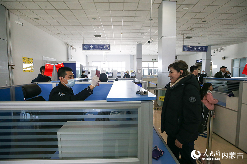 二連出入境邊防檢查站移民管理警察為旅客辦理通關(guān)手續(xù)。郭鵬杰攝