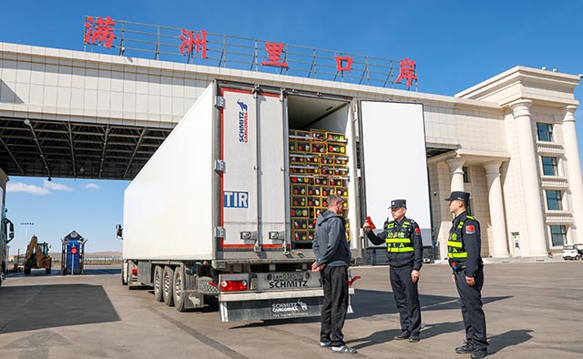 滿洲里邊檢站民警查驗出口果蔬貨車員工證件，李發(fā)春攝