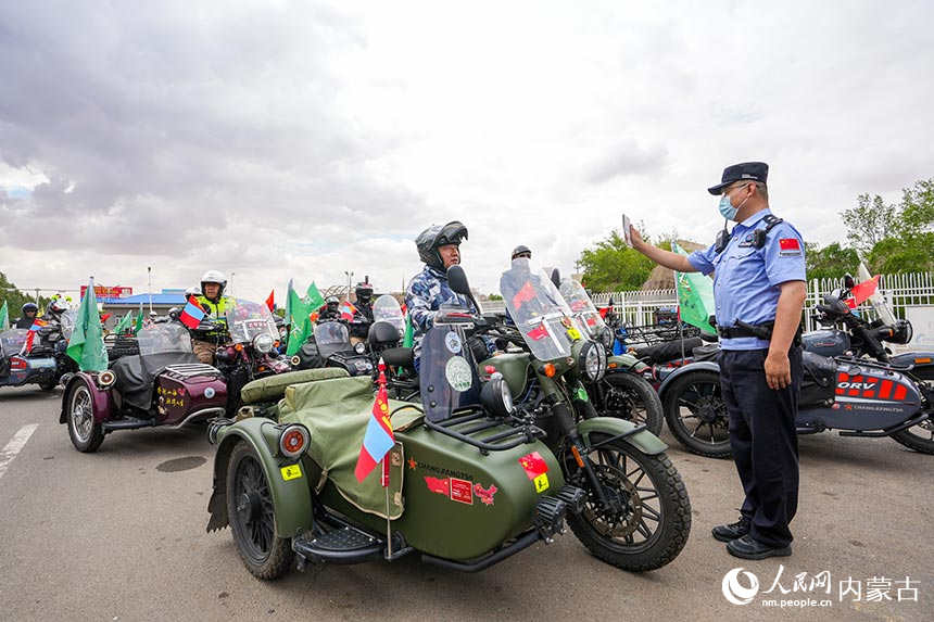 二連出入境邊防檢查站移民管理警察查驗(yàn)?zāi)ν熊囎择{旅游團(tuán)成員通關(guān)證件。楊金燁攝
