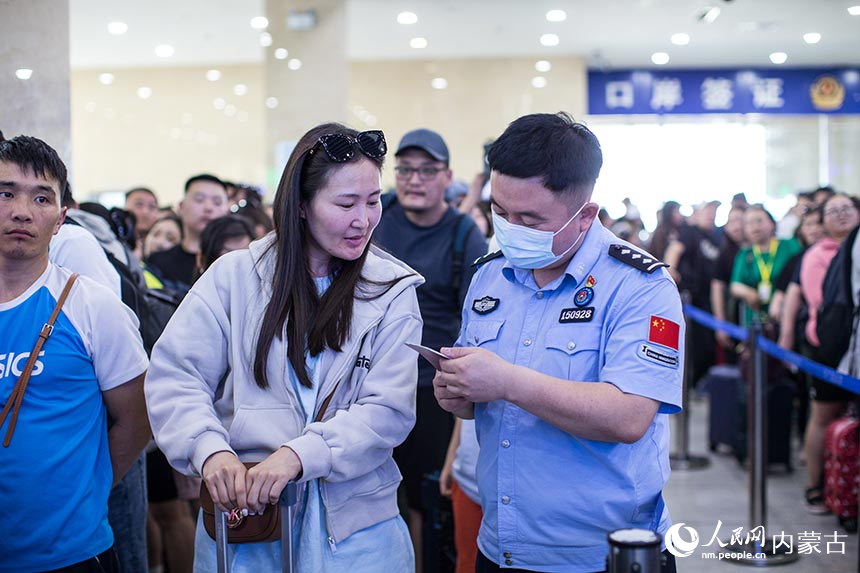 二連出入境邊防檢查站移民管理警察為旅客提供通關(guān)咨詢。郭鵬杰攝