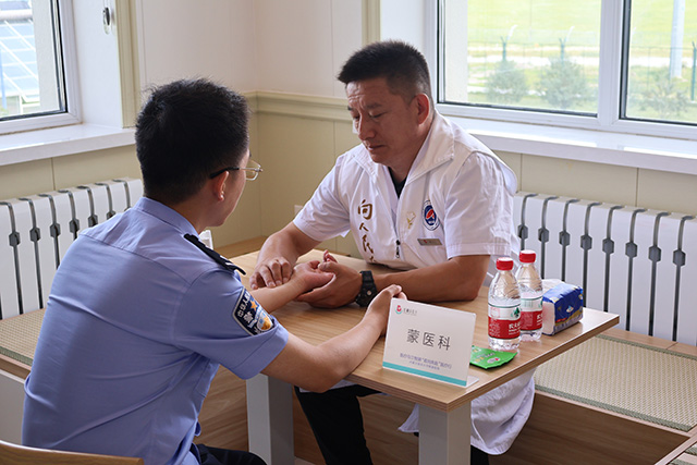 蒙醫(yī)醫(yī)生正在為民警把脈問診。