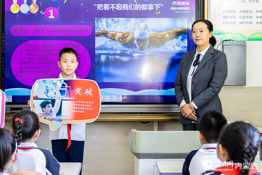 呼和浩特市玉泉區(qū)石東路小學(xué)學(xué)生在“開學(xué)第一課”上向小伙伴們分享奧運(yùn)健兒拼搏的故事。丁根厚攝