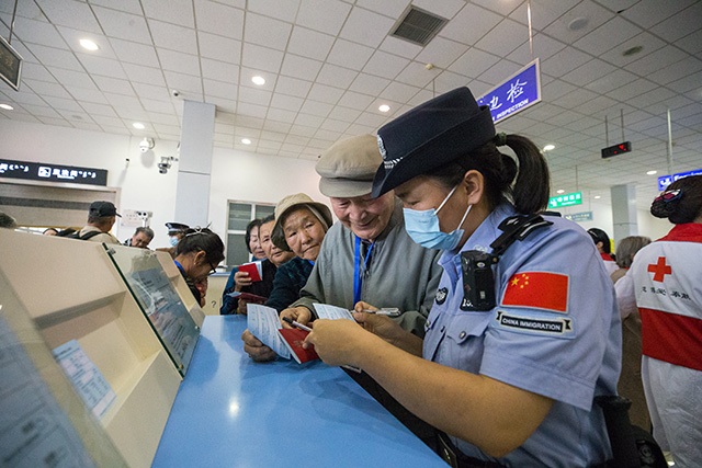 圖4：2024年9月9日，二連出入境邊防檢查站移民管理警察幫助旅客填寫外國人入境登記卡。