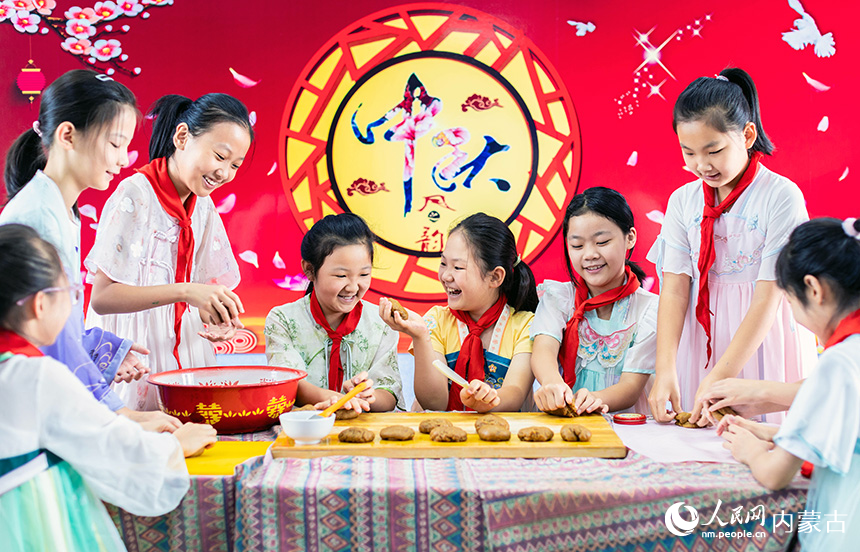 呼和浩特市玉泉區(qū)恒昌店巷小學(xué)學(xué)生在學(xué)習(xí)制作手工月餅。丁根厚攝