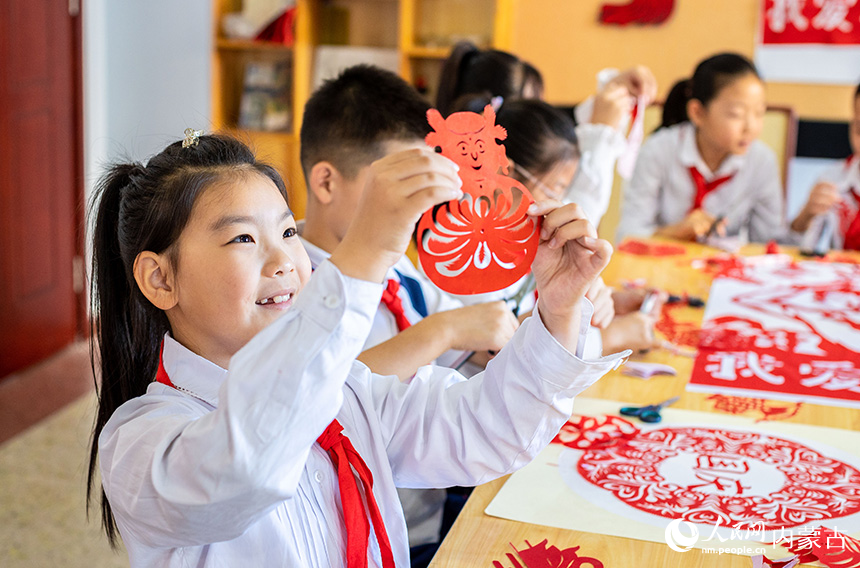呼和浩特市玉泉區(qū)恒昌店巷小學(xué)五里營校區(qū)的學(xué)生在制作迎國慶主題的剪紙作品。丁根厚攝