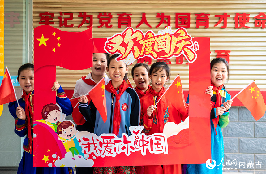 呼和浩特市玉泉區(qū)南柴火市街小學師生在“童心頌祖國 歡歌迎國慶”主題活動現(xiàn)場打卡拍照。丁根厚攝