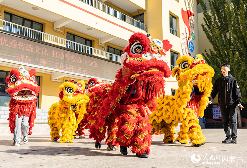 呼和浩特市玉泉區(qū)清泉街小學(xué)學(xué)生在專業(yè)老師的指導(dǎo)下練習(xí)舞獅步伐。丁根厚攝