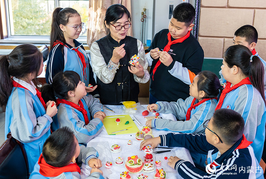 呼和浩特市玉泉區(qū)清泉街小學(xué)學(xué)生在老師的指導(dǎo)下體驗(yàn)面塑獅子的制作技藝。丁根厚攝