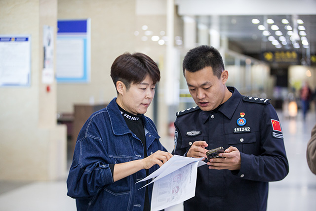 圖2：2024年10月31日，二連出入境邊防檢查站民警為旅行社負(fù)責(zé)人介紹“邊檢通”備案預(yù)約服務(wù)平臺(tái)功能。
