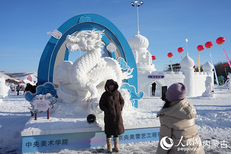 游客與雪雕合影。人民網(wǎng)記者 趙夢月攝