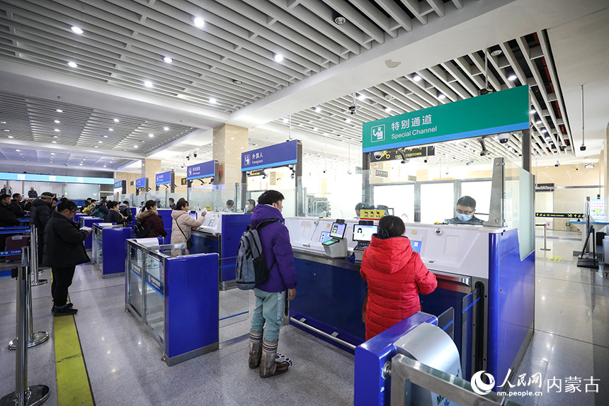 二連出入境邊防檢查站移民管理警察為旅客辦理通關(guān)手續(xù)。郭鵬杰攝