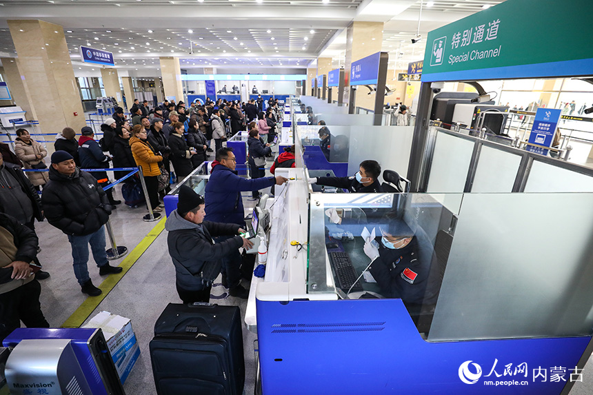 2024年12月9日，二連出入境邊防檢查站移民管理警察為旅客辦理通關(guān)手續(xù)。郭鵬杰攝