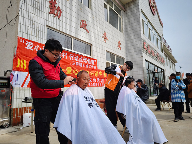 志愿者為村民免費(fèi)理發(fā)。