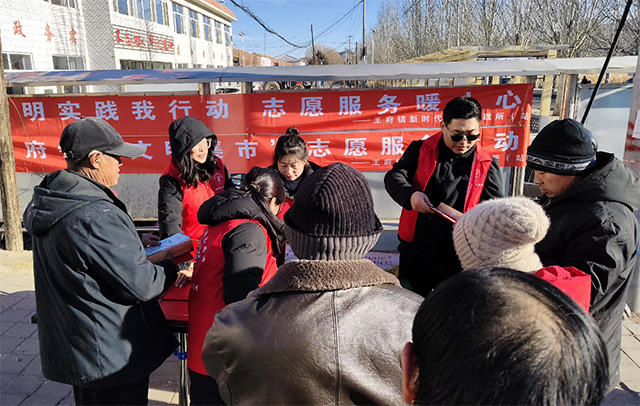 志愿者在集市為村民發(fā)放新年臺(tái)歷和宣傳防火知識(shí)。