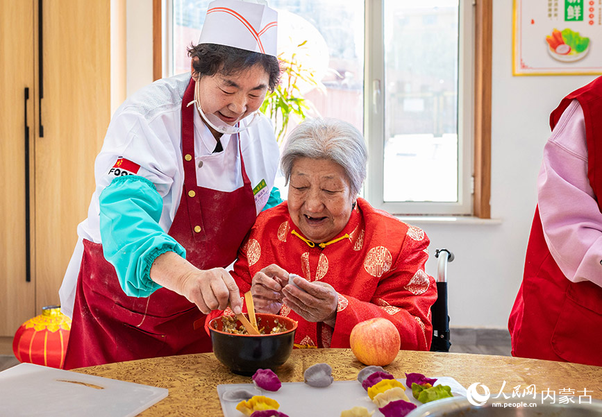 1月20日，工作人員與老人們?cè)诤艉秃铺厥杏袢獏^(qū)民政局迎新春主題活動(dòng)現(xiàn)場(chǎng)一起包餃子。丁根厚攝