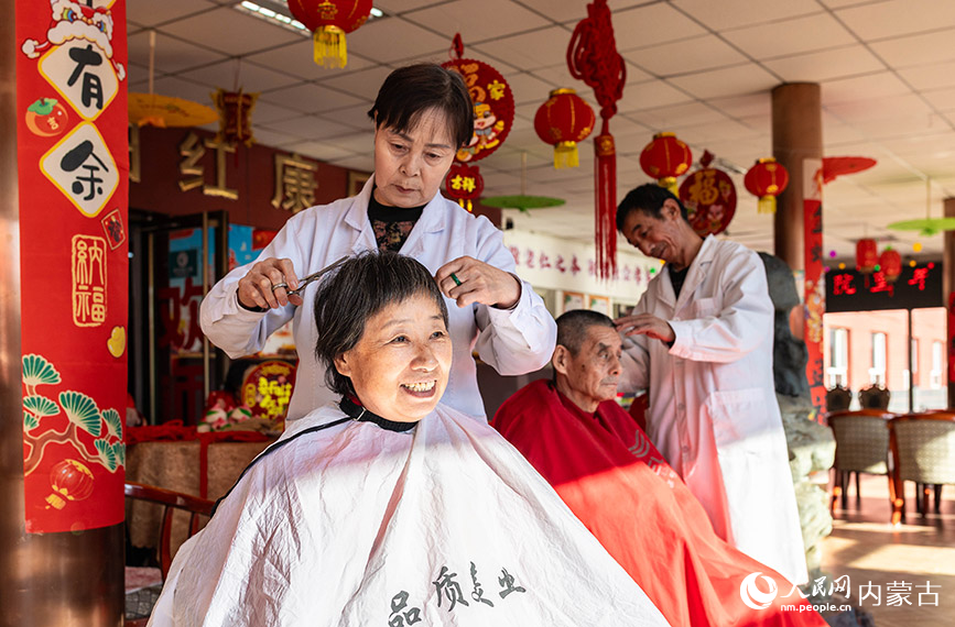 1月20日，工作人員在呼和浩特市玉泉區(qū)民政局迎新春主題活動現(xiàn)場為老人們理發(fā)。丁根厚攝