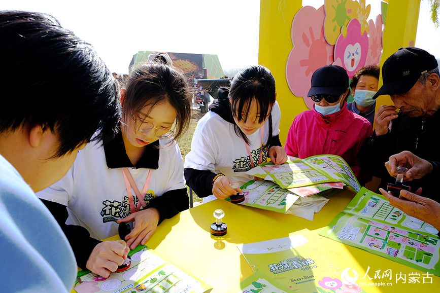 “花漾青城”2025呼和浩特賞花季系列文旅活動(dòng)開啟，市民正在開幕式現(xiàn)場(chǎng)集章打卡。人民網(wǎng)記者 劉藝琳攝